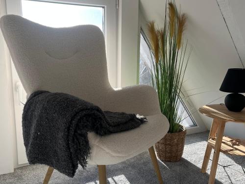 a blanket sitting on a chair in a living room at Zeitapartments Altstadtlage in Stade