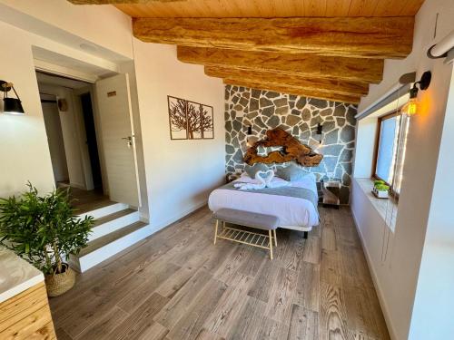a bedroom with a stone wall with a bed in it at La Casucha de Chulilla in Chulilla