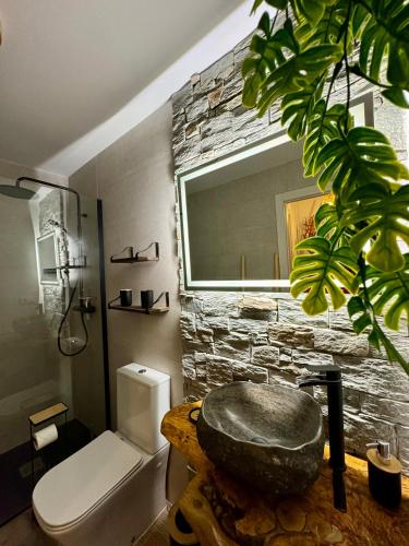 a bathroom with a rock sink and a stone wall at La Casucha de Chulilla in Chulilla