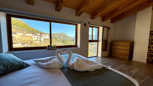 1 Schlafzimmer mit 2 Schwänen auf einem Bett mit Aussicht in der Unterkunft La Casucha de Chulilla in Chulilla