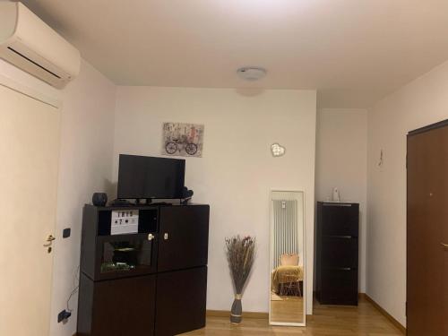 ein Wohnzimmer mit einem TV und einem schwarzen Schrank in der Unterkunft Grazioso appartamento a Osteria Nuova in Sala Bolognese