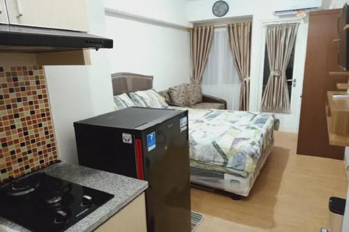uma sala de estar com uma cozinha com uma cama em Velito at Podomoro Golf View Apartment em Kampungsitu