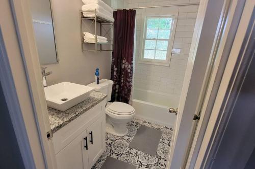 a white bathroom with a sink and a toilet at Cozy 3BR house near downtown Spartanburg. in Spartanburg