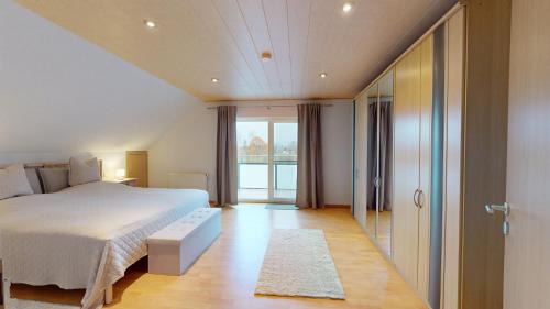 a bedroom with a bed and a sliding glass door at Ferienhaus Hoffmann am Rheinbogen in Altlußheim