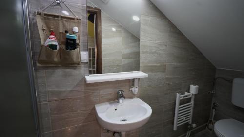a bathroom with a sink and a toilet and a staircase at Hideaway Rooms & Apartments Sarajevo in Sarajevo