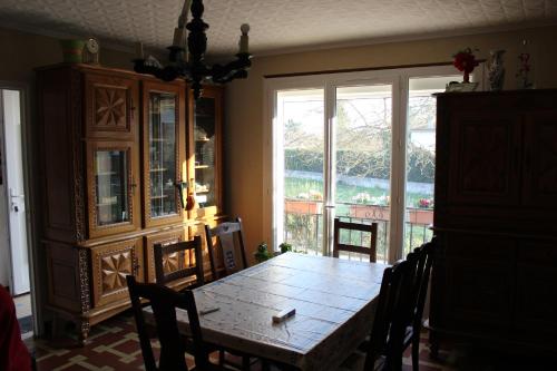 a dining room with a table and a large window at MAISON DE PLEIN PIED CLIMATISEE in Masseube