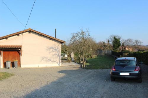 a car parked in the driveway of a house at MAISON DE PLEIN PIED CLIMATISEE in Masseube