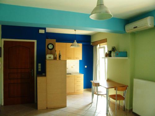 a kitchen with blue walls and a table and chairs at Casa di Maura in Lefkada Town