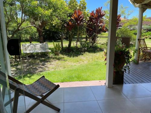a chair sitting on a porch looking out at a yard at São Francisco do Sul, SC, Praia do Forte. in São Francisco do Sul