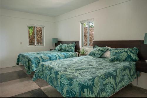 sypialnia z 2 łóżkami i 2 oknami w obiekcie Apartamento en Río San Juan a 4 minutos de playas piscina con agua caliente w mieście Río San Juan