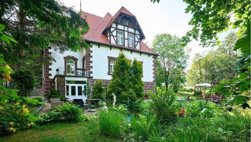 uma casa com um jardim em frente em Willa Pałacyk em Świeradów-Zdrój