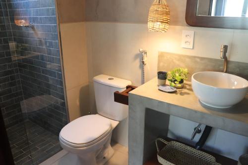 a bathroom with a toilet and a sink and a shower at Zenhousepipa in Pipa