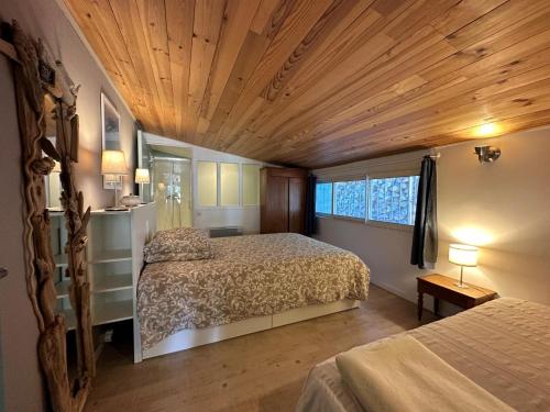 1 dormitorio con 2 camas y techo de madera en La Casserina, en Lorgues