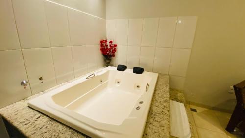 a white bath tub sitting in a bathroom at Hotel Nova Aliança in Chapadão do Sul