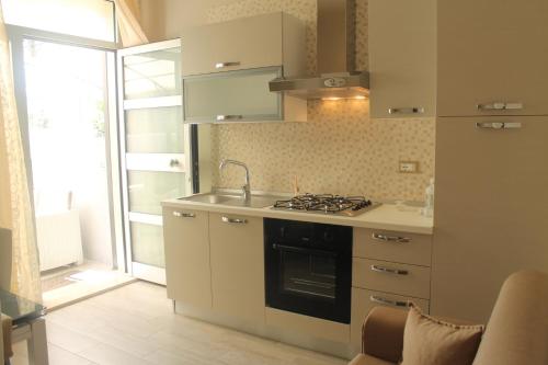 una cucina con lavandino e piano cottura forno superiore di Appartamenti Sole&Mare a Polignano a Mare