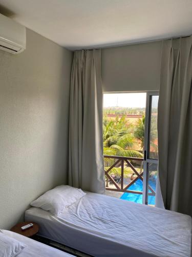 a bedroom with a bed and a window with a view at Apto Praia da Taíba Vista Mar in Taíba
