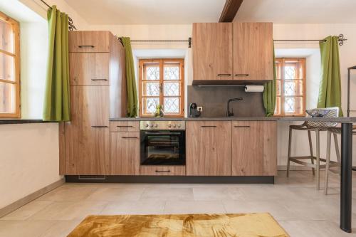a kitchen with wooden cabinets and a stove at Haus.1800 in Altenmarkt im Pongau