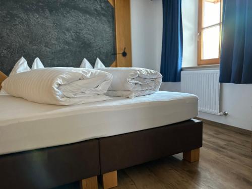 a bed with white pillows on it in a room at Apartment Steinbock in Samnaun