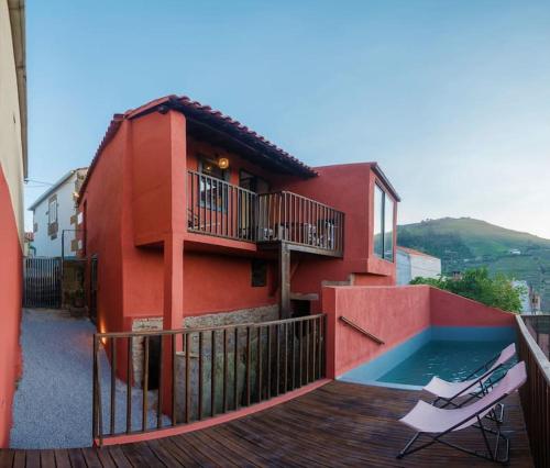 a red house with a swimming pool and a deck at BABhouse Casa do Avô Pedoucas - Coração do Douro in Nagoselo do Douro