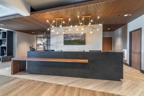 a lobby with a black reception desk with lights at Cambria Hotel Lake Placid - Lakeside Resort in Lake Placid