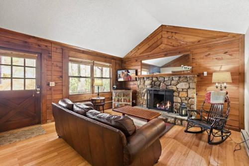 ein Wohnzimmer mit Couch und Kamin in der Unterkunft Picturesque Riverside Cabin with Fireplace and Porch in Blowing Rock