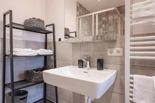 a white sink in a small bathroom with towels at Haus.1800 in Altenmarkt im Pongau