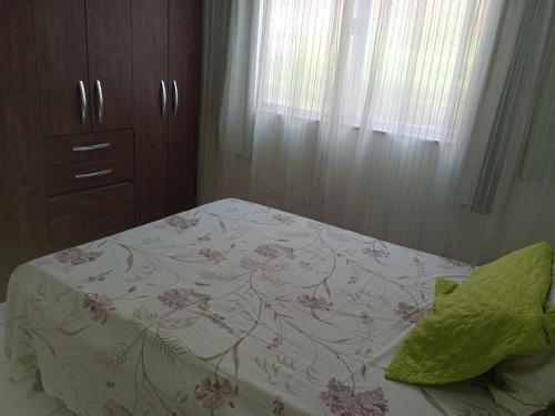 里約熱內盧的住宿－Apto lapa，一间卧室配有一张带白色床罩和鲜花的床