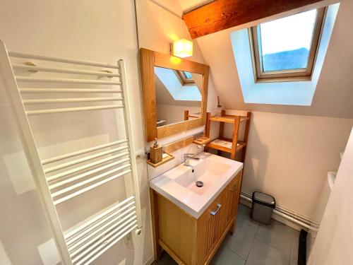une salle de bain avec un lavabo et un miroir dans l'établissement La perle Bressaude avec balcon et magnifique vue, à La Bresse