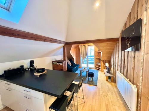 une cuisine avec un comptoir noir dans une pièce dans l'établissement La perle Bressaude avec balcon et magnifique vue, à La Bresse