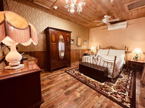 1 dormitorio con 1 cama y 1 mesa con lámpara en The Russ House, en Tombstone