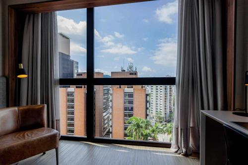 a room with a large window with a view of a city at LK Design Hotel Florianópolis in Florianópolis