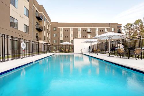 a swimming pool in front of a building at WaterWalk Extended Stay by Wyndham Jacksonville Deerwood Pk in Jacksonville