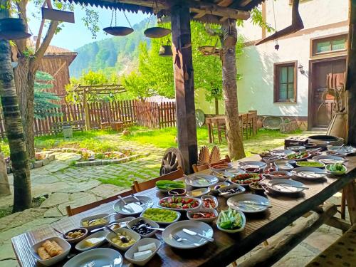 a wooden table with plates of food on it at Hacı Şakirler Konağı in Mudurnu