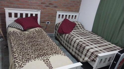 two beds sitting next to each other in a room at La morada del arroyo in Villa Santa Cruz del Lago