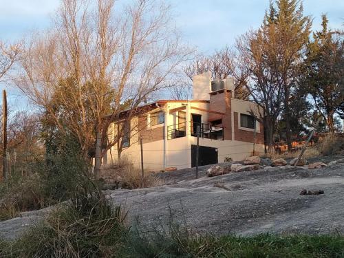 a house sitting on top of a rocky hill at La morada del arroyo in Villa Santa Cruz del Lago