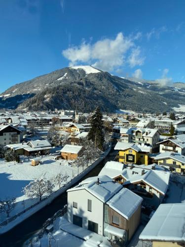 a snowy city with a mountain in the background at Loft im Turm in Maishofen