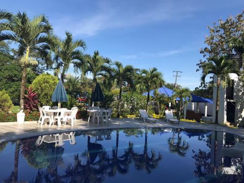 a pool with tables and chairs and palm trees at Quinta El Diamante in Villavicencio