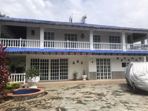 a white house with a car parked in front of it at Quinta El Diamante in Villavicencio