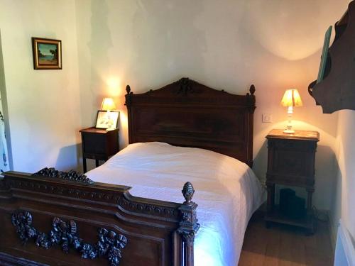 sypialnia z dużym drewnianym łóżkiem i 2 lampami w obiekcie Maison de 4 chambres avec jardin amenage a Naucelles 