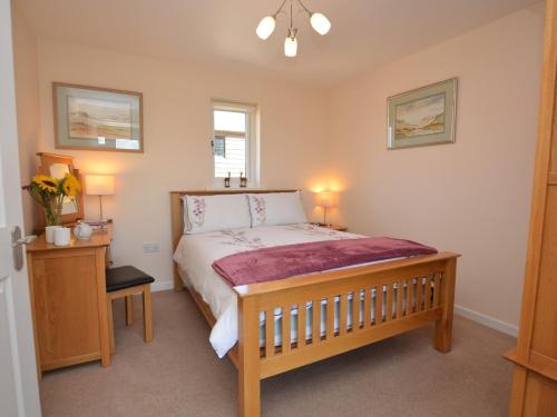 a bedroom with a large bed and two lamps at 1 bed in Bude SCADG in Poughill