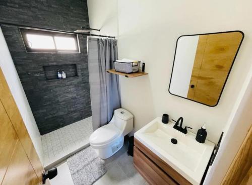 y baño con aseo, lavabo y espejo. en La Ventana Apartments View Island #4, en La Ventana