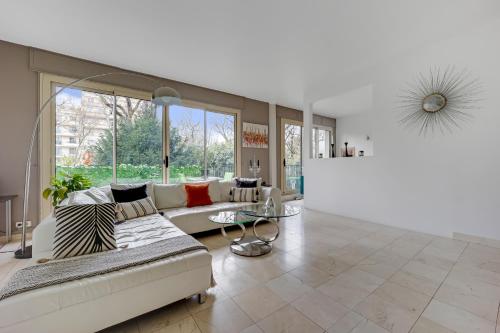 uma sala de estar com um sofá e uma mesa em Bel appartement 3 pièces 2 chambres 76M2 + balcon + Parking em Neuilly-sur-Seine