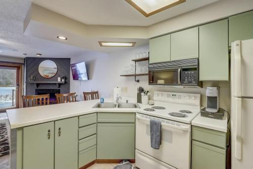 a kitchen with green cabinets and white appliances at Stephs Waterfront Retreat Sunset Cove 303 in Wisconsin Dells