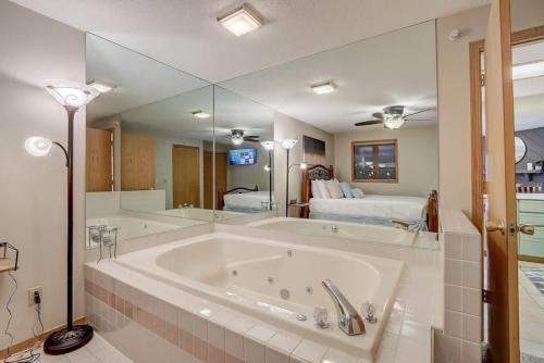 a large bath tub in a room with a bedroom at Stephs Waterfront Retreat Sunset Cove 303 in Wisconsin Dells
