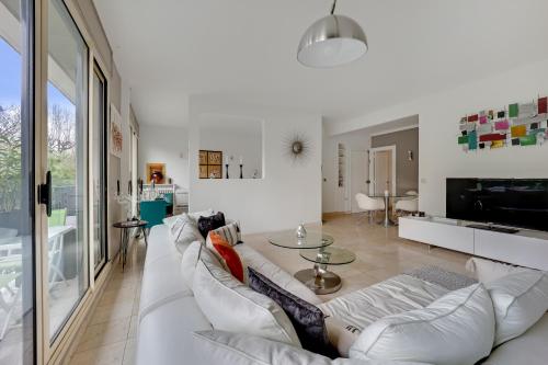 un salon avec un canapé blanc et une table dans l'établissement Bel appartement 3 pièces 2 chambres 76M2 + balcon + Parking, à Neuilly-sur-Seine