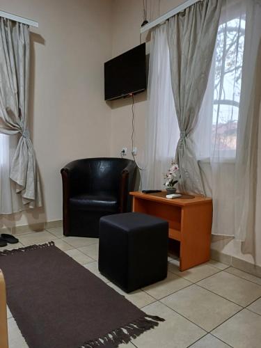 - un salon avec un fauteuil en cuir noir et une table dans l'établissement Sobe SANjA, à Pirot
