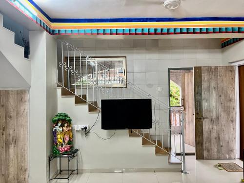 a living room with a tv and a staircase at Ladakh House- 3 BHK Ladakh themed Villa near Matheran in Neral