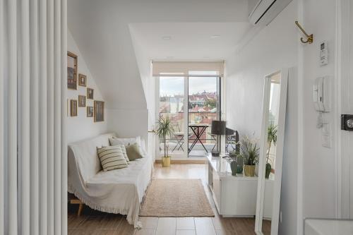a white living room with a couch and a window at Romantic Gem with 2 Terraces in Alcântara in Lisbon