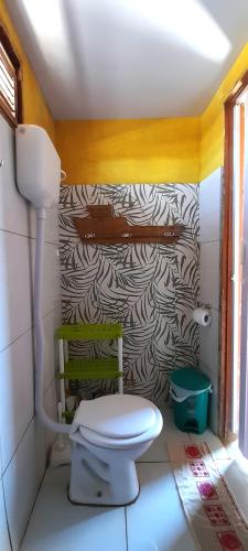 a bathroom with a toilet and a wall at Chalé R Paz Macapá in Luis Correia