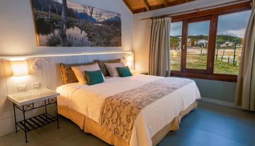 Un dormitorio con una cama grande y una ventana en Tolkeyen Ushuaia Hotel en Ushuaia